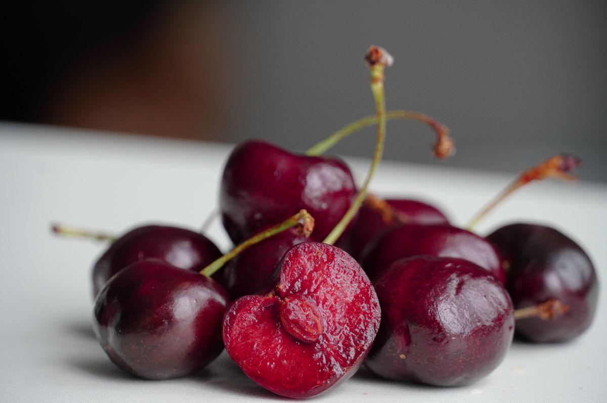 Fresh cherries with stems on a white plate