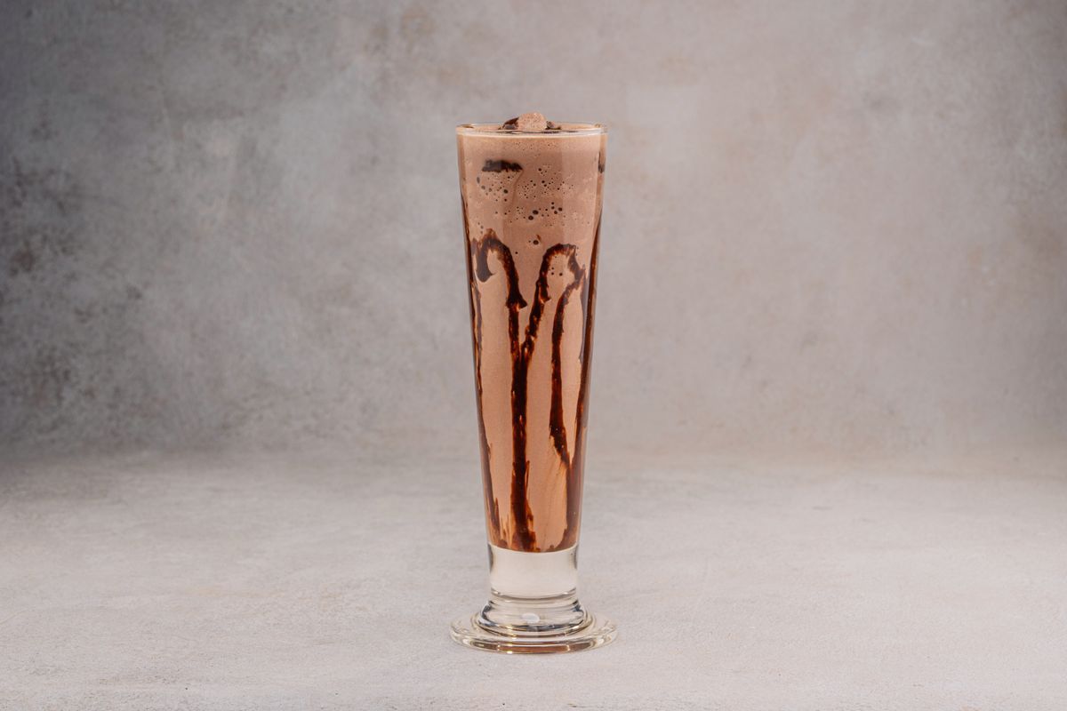 Chocolate milkshake with chocolate drizzle in a tall glass