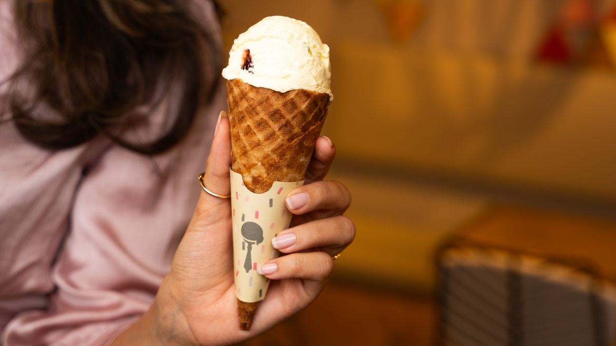 A scoop of vanilla ice cream held in a cone