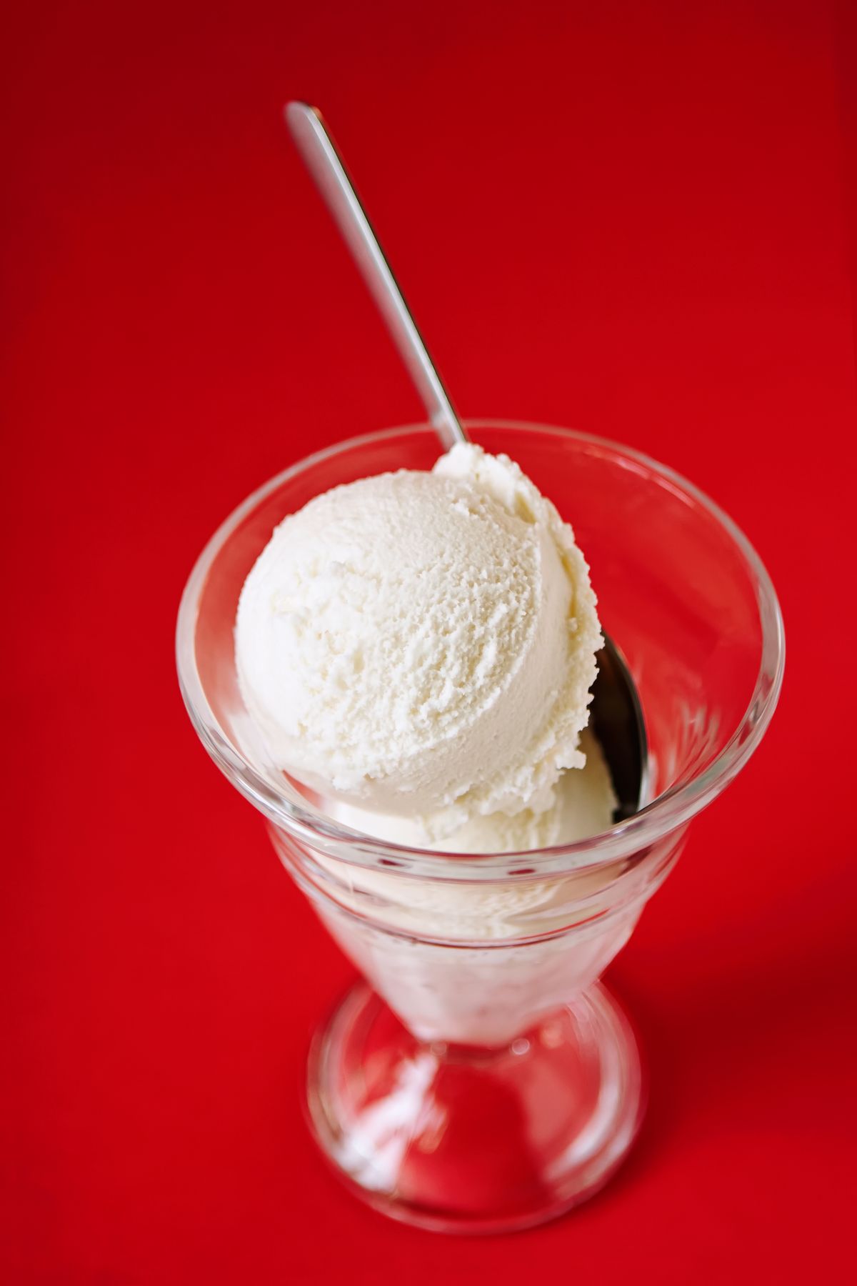 Scoop of vanilla ice cream in a glass dessert dish
