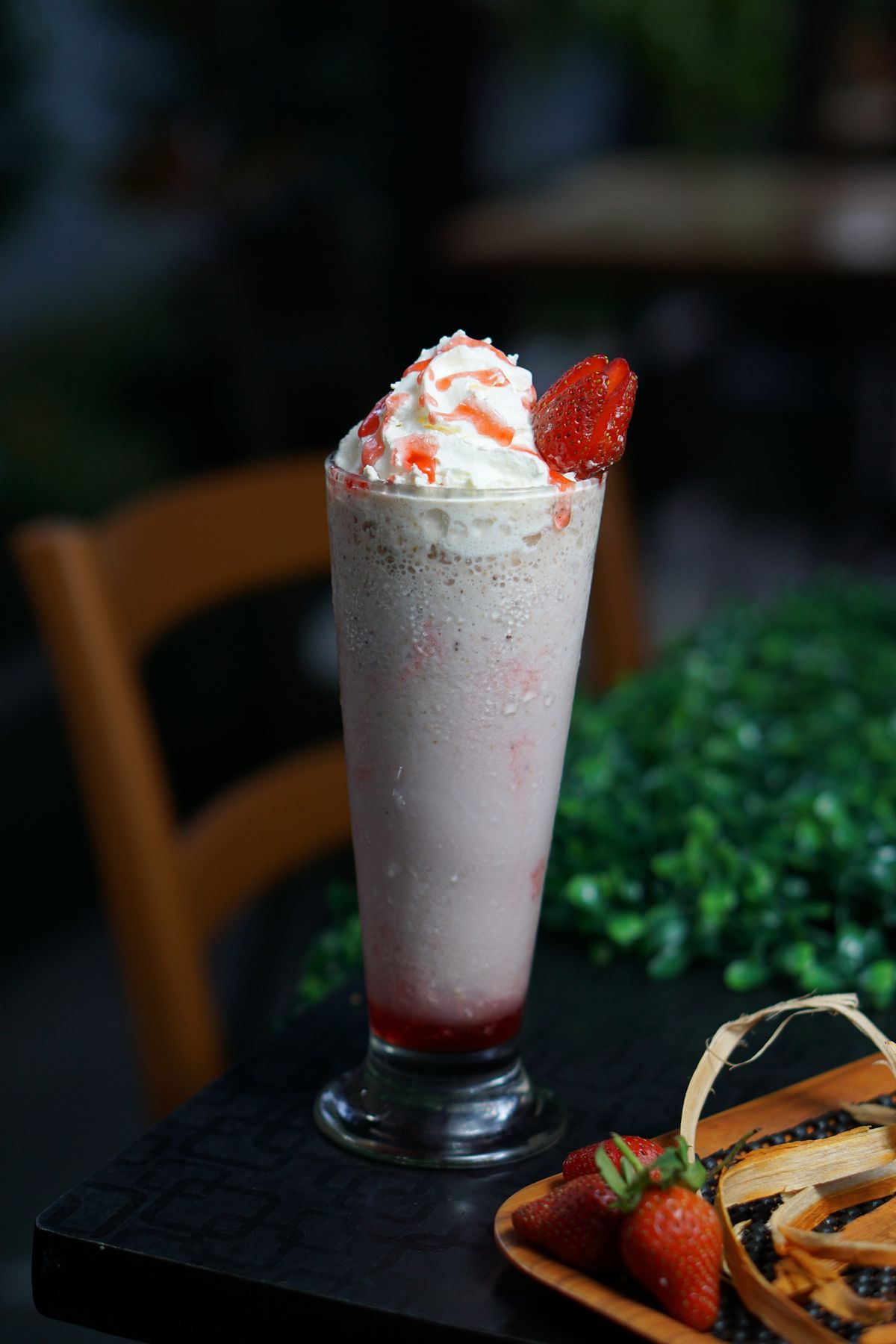 Pink strawberry milkshake with whipped cream and strawberries