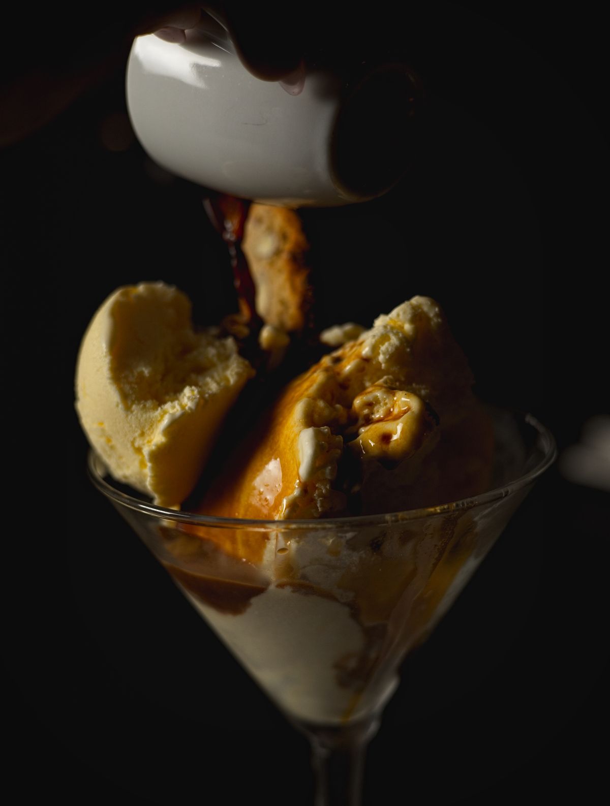Espresso being poured over vanilla ice cream